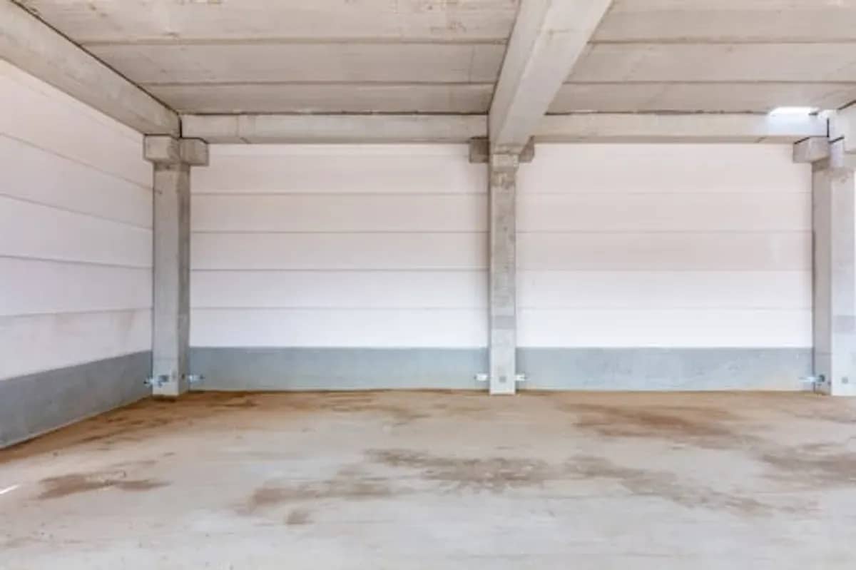 Remodeled residential garage interior with finished walls and sealed floor coating