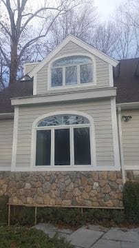 Replacement arched windows and trim work on a newly sided home exterior in Stamford, CT
